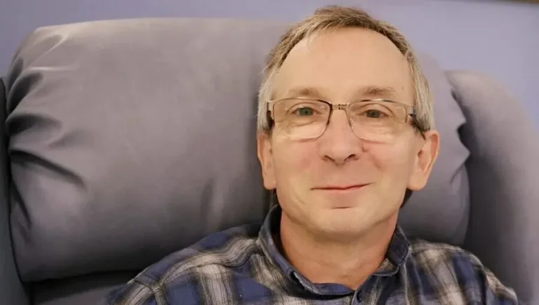 The author sits in a chair before his first chemotherapy session, smiling, still unaware of what lies ahead.