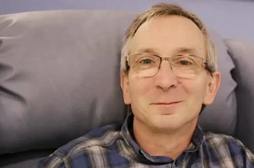 The author sits in a chair before his first chemotherapy session, smiling, still unaware of what lies ahead.
