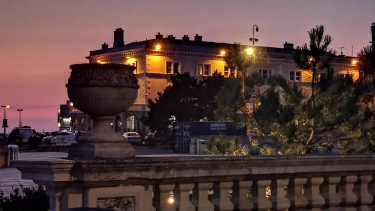A warmly lit historic building in Weston‑super‑Mare at night, with architectural details glowing against the dusk sky.
