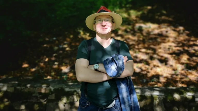 The author of the blog standing against the backdrop of lush greenery at Ilam Hall, smiling despite undergoing treatment.