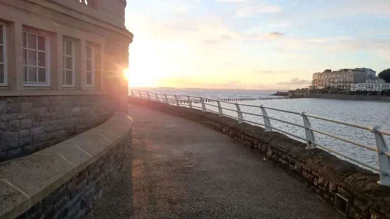 A sunset view from beside Stones Cafe in Weston‑super‑Mare, with the closed Anchor Head Hotel visible in the distance across the water.