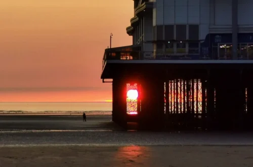 The setting sun framed perfectly between the supporting structure of the pier in Weston‑super‑Mare.