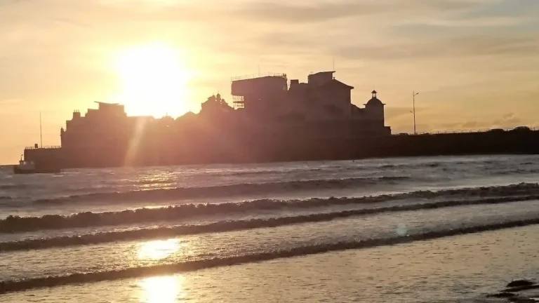 A sunset view from the promenade in Weston‑super‑Mare, with the buildings of Knightstone Island silhouetted against the glowing horizon.
